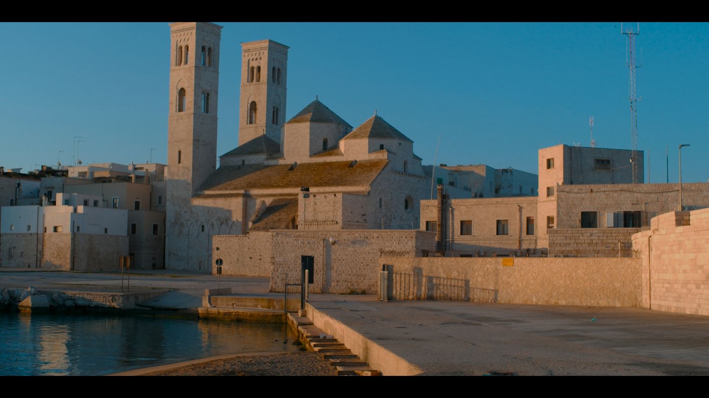 Plaza con una iglesia de dos torres contra un cielo limpio.